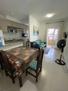 a kitchen and dining room with a table and chairs at Lindo Apartamento em Bertioga/SESC a 300m da praia in Bertioga