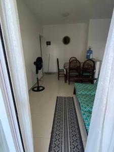 a room with two beds and a table and chairs at Lindo Apartamento em Bertioga/SESC a 300m da praia in Bertioga