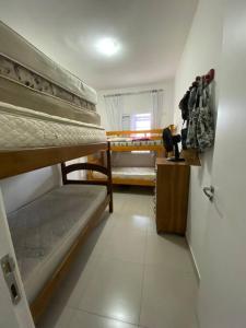 a room with two bunk beds in a room at Lindo Apartamento em Bertioga/SESC a 300m da praia in Bertioga