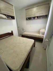 a small room with two beds and a table at Lindo Apartamento em Bertioga/SESC a 300m da praia in Bertioga