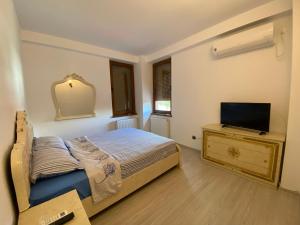 a bedroom with a bed and a flat screen tv at Apartament 3 camere in Bacău