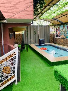 a backyard with a pool with green grass at Owee Hotel Apartment and Suites in Lagos
