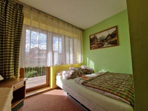 a bedroom with a bed in front of a window at Pokoje Gościnne u Lańdy in Poronin