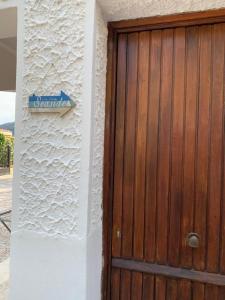 une porte en bois avec un panneau sur le côté du bâtiment dans l'établissement casa vacanze Sicilia Bedda Seaside, à Santa Flavia