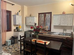a kitchen with a table with a vase of flowers on it at La casa di Mary in Castiglion Fiorentino