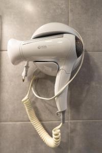 a hair dryer is hanging on a wall at Leevin Guesthouse in Faro