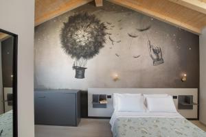 - une chambre avec un lit et une peinture murale dans l'établissement Theodore Rooms, à San Teodoro