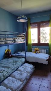 1 dormitorio con 2 literas y ventana en La casa del fresno, en Pinilla del Valle
