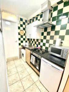 a kitchen with green and white checkered wall at Ground Floor One Bed Studio In London in London