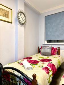 a bedroom with a bed with a clock on the wall at Ground Floor One Bed Studio In London in London