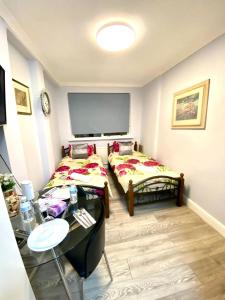 a room with two beds and a table in it at Ground Floor One Bed Studio In London in London