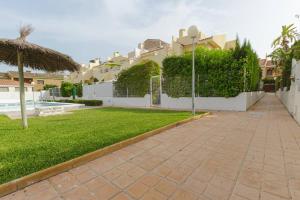 a walkway in front of a building with a yard at Bungalow con encanto in San Juan de Alicante