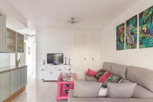 sala de estar con sofá y TV en Bungalow con encanto, en San Juan de Alicante