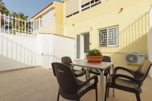 una casa y un patio con mesa y sillas en Bungalow con encanto, en San Juan de Alicante