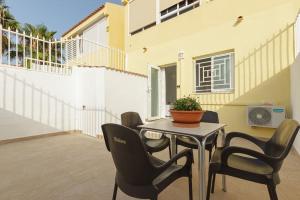 a patio with a table and chairs and a house at Bungalow con encanto in San Juan de Alicante