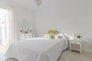 a white bedroom with a white bed and two mirrors at Bungalow con encanto in San Juan de Alicante +36 photos