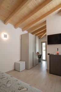 a living room with white walls and a wooden ceiling at Theodore Rooms in San Teodoro