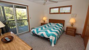 Un dormitorio con una cama y un escritorio y una ventana. en Oceanside, Community Pool, Community Tennis, PT7, Summer Winds, en Sanderling