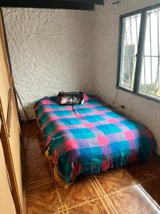 a bed in a room with a colorful blanket at FINCA VILLA DEL CARMEN in Sibaté