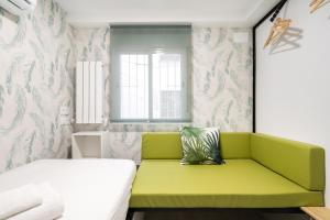 a green bench in a room with a bed at ALCALA QUINTANA - 3 Bedrooms in Madrid