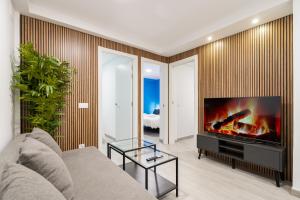 a living room with a couch and a flat screen tv at ALCALA QUINTANA - 3 Bedrooms in Madrid