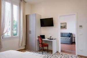 a bedroom with a desk and a tv on a wall at LaMì Room & Apartment in Castel San Pietro Terme