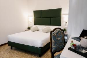 een slaapkamer met een bed met een groen hoofdeinde bij LaMì Room & Apartment in Castel San Pietro Terme