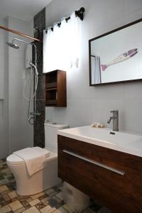 uma casa de banho com um lavatório, um WC e um chuveiro em Oslob Whale Shark Resort em Oslob