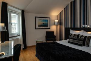 ein Hotelzimmer mit einem Bett und einem Stuhl in der Unterkunft Quality Hotel Statt in Hudiksvall