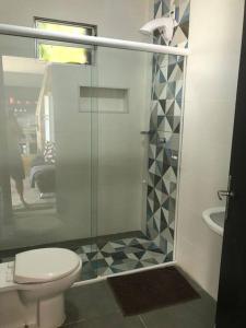 een badkamer met een toilet en een glazen douche bij Studio panorâmico vista mar in São José