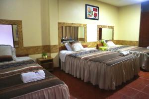 a hotel room with two beds and two mirrors at HOSTAL SOL & LUNA in Huánuco