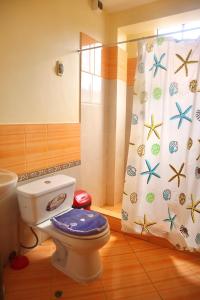 a bathroom with a toilet and a shower curtain at HOSTAL SOL & LUNA in Huánuco