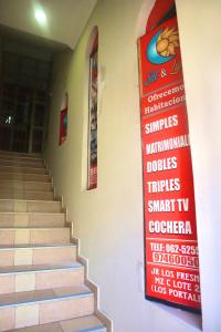 un escalier avec un panneau sur le mur dans l'établissement HOSTAL SOL & LUNA, à Huánuco