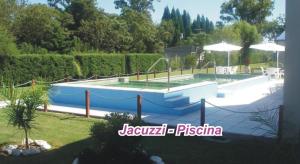 una piscina en un patio junto a un jardín en Cabañas Costa Azul en Sauce Viejo