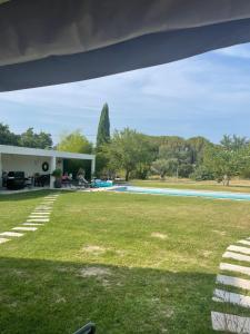 een huis met een tuin met een zwembad bij Villa avec Pool House au cœur des vignes - Lubéron in La Tour-dʼAigues