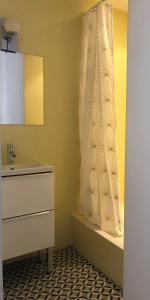 baño con lavabo y cortina de ducha en Seventies, vintage et bohème, en Bourgoin