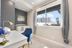 ピッツバーグにあるHostWise Stays - Great Balcony Views, Patio, Minutes to Stadiumsのデスク、窓、青い椅子が備わる客室です。