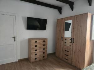 a bedroom with a wooden cabinet and a mirror at HOUSE SAL Y MAR in Arrieta