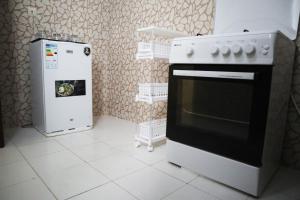 a kitchen with a stove and a refrigerator at Chez Mamanta in Saint-Louis