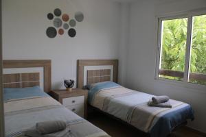 a bedroom with two beds and a window at Las Terrazas De La Torre Golf Resort - Sueño De Los Hermanos in Roldán +26 photos