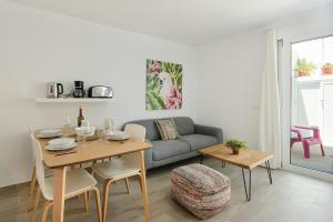 un salon avec une table et un canapé dans l'établissement Purple Volcano- pool, gym and activities in Sport Center Fariones included, à Puerto del Carmen