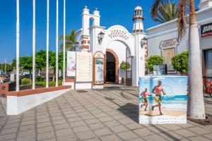 une rue en face d'une église avec une photo de deux personnes dans l'établissement Purple Volcano- pool, gym and activities in Sport Center Fariones included, à Puerto del Carmen