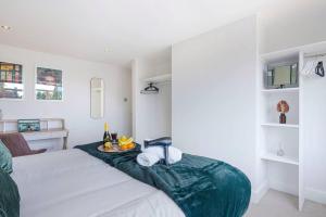 a bedroom with a bed with a green blanket at Stunning 2 Bedroom Apartment - Close to City Centre - Free Parking, Super-fast WIFI, SmartTV, Private Balcony and Communal Garden by Yoko Property in Coventry