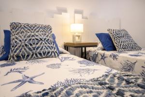 une chambre avec deux lits avec des draps bleus et blancs dans l'établissement White Volcano pool, gym and activities in Sport Center Fariones included, à Puerto del Carmen 30 autres photos