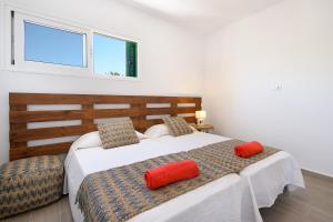 une chambre avec un lit avec des oreillers rouges dessus dans l'établissement Green Volcano- pool, gym and activities in Sport Center Fariones included, à Puerto del Carmen 27 autres photos