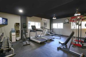 a gym with several tread machines and a clock at Central Park Tower in Santo Domingo