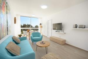 un salon avec un canapé bleu et une table dans l'établissement Red Volcano- pool, gym and activities in Sport Center Fariones included, à Puerto del Carmen