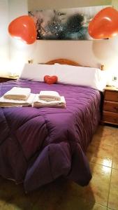 Una cama con edredón púrpura y toallas. en Casa Placet de Sant Joan Apto, en Morella
