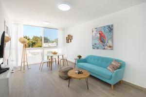 uma sala de estar com um sofá azul e uma mesa em Blue Volcano-pool, gym and activities in Sport Center Fariones included em Puerto del Carmen