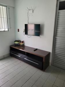 einen Flachbild-TV, der an einer Wand hängt in der Unterkunft PRAIA DE 4 ILHAS Apartamento 2 Quartos 60M Da Praia Com Vista in Bombinhas